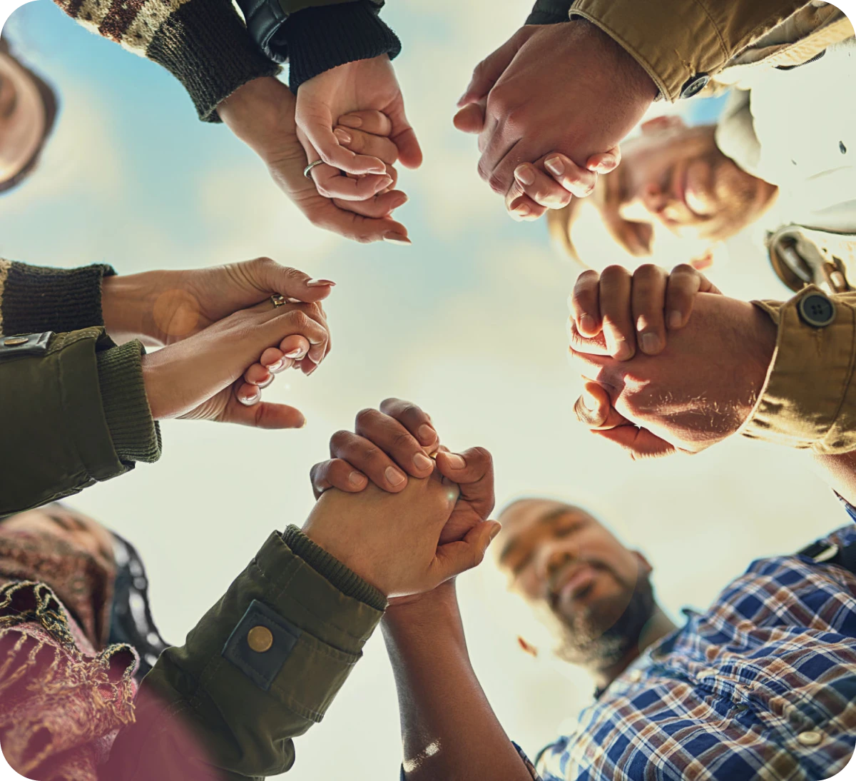 Diverse group joining hands together